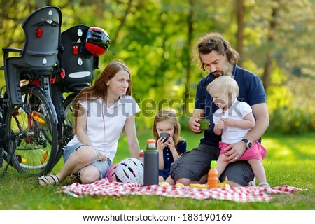 Happy family of four picnicking in the park