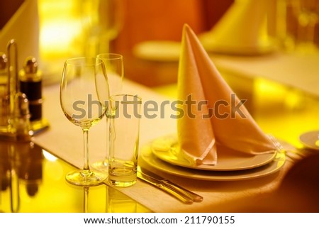 Table set for an event party or wedding reception in yellow light
