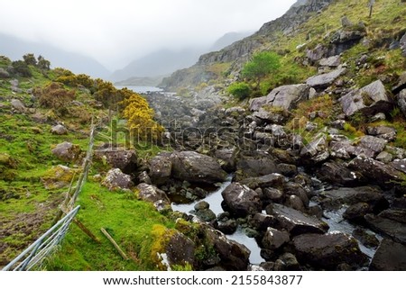 The River Loe and narrow mountain pass road wind through the steep valley of the Gap of Dunloe, nestled in the Macgillycuddys Reeks mountains, County Kerry, Ireland Stok fotoğraf © 