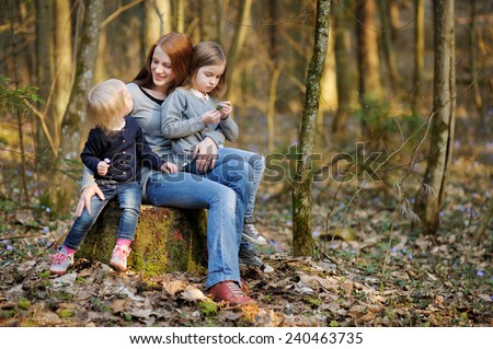 Happy young mother and her little daughters on beautiful spring day outdoors