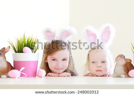 Two adorable little sisters wearing bunny ears on Easter day