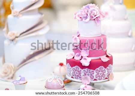 White wedding cake decorated with pink sugar flowers