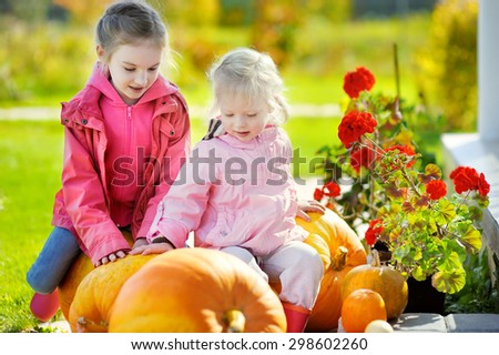 Two little sisters and some huge pumpkins on a pumpkin patch