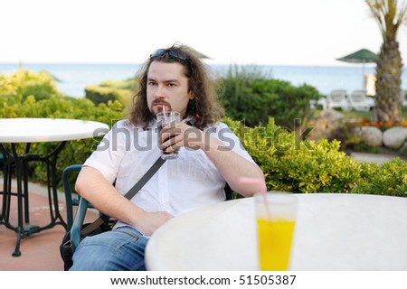 Young man drinking juice at a resort