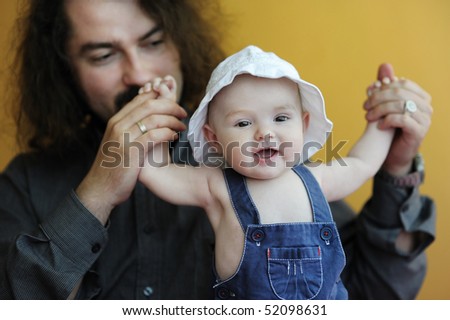 Three month old baby girl laughing in fathers hands