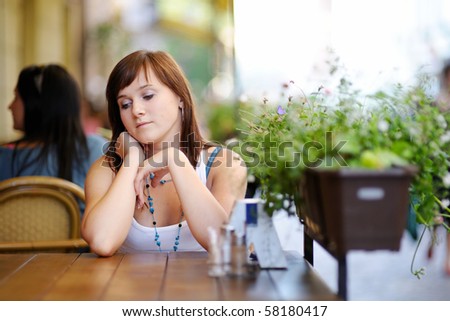 Young attractive woman sitting in outdoor cafe