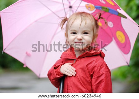 Adorable toddler girl at rainy day in autumn