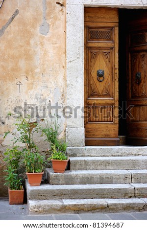 Old wooden door with flowers on the stairs