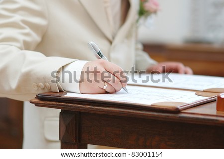Groom signing marriage license or wedding contract