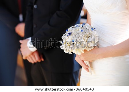 Bride holding flowers at the wedding ceremony in church
