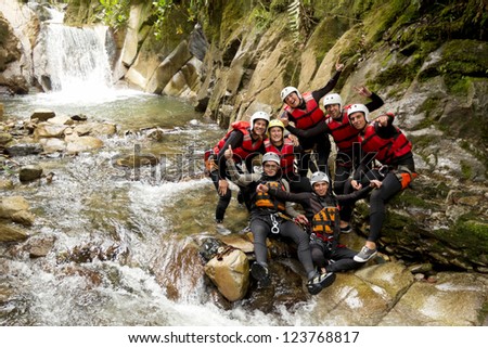 GROUP OF ACTIVE YOUNG PEOPLE DURING A CANYONING EXPEDITION IN ECUADORIAN RAINFOREST