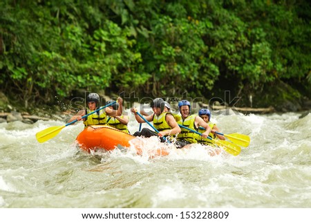A GROUP OF MEN AND WOMEN, WITH A GUIDE, WHITE WATER RAFTING ON THE PATATE RIVER, ECUADOR