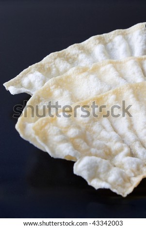 Selective close-up image of an Indian snack, called Papadum which is a thin crispy flatbread.