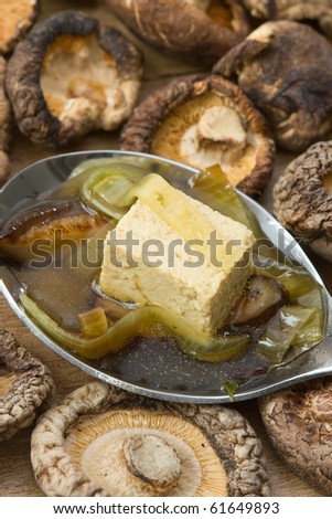 Spoon with Japanese vegetarian broth made from mushrooms, tofu and leek