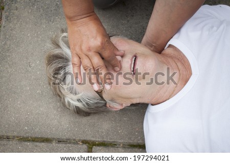 A sick senior old lady receiving mouth to mouth resuscitation, kiss of life