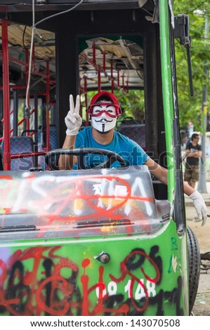 ISTANBUL - JUNE 06, 2013: Man with mask in damaged bus during protests on June 06, 2013 in Istanbul, Turkey. Guy Fawkes masks widely used and became a symbol of protests in Turkey.