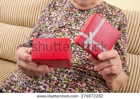 senior woman opening gift box