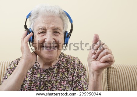 happy and energetic senior woman listening music with headphones
