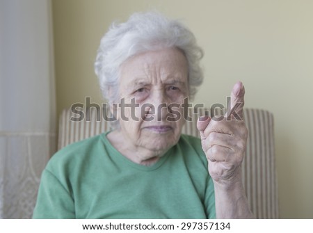 senior woman warning with her finger up