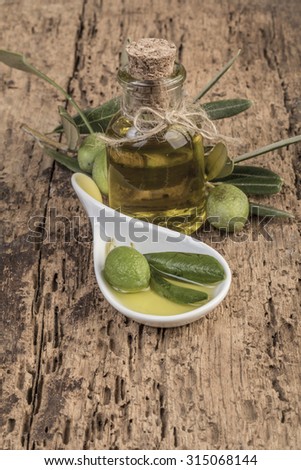 olives and olive oil bottle on wooden table