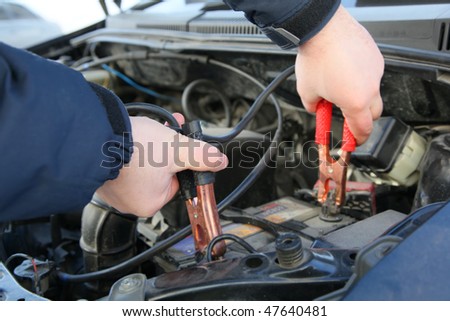 mechanic changing the battery of a car