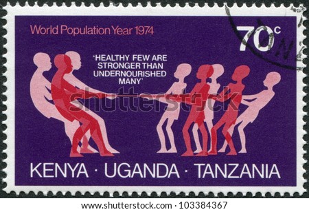 EAST AFRICAN COMMUNITY - CIRCA 1974: A stamp printed in East African Community, is dedicated to World Population Year, shows a tug of war with the malnourished, circa 1974