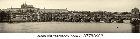 PRAGUE, CZECH REPUBLIC - FEBRUARY 02, 2014: Panoramic view of old Prague, Charles Bridge and St. Vitus Cathedral. Sepia. Stylized film. Large grains.