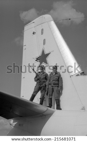 MOSCOW REGION, RUSSIA - CIRCA 1993: Soldiers stand on a military transport plane An-24. Film scan. Large grain, circa 1993