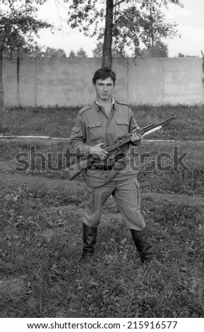 MOSCOW REGION, RUSSIA - CIRCA 1993: A soldier posing with guns. Film scan. Large grain, circa 1993