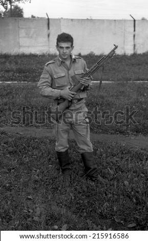 MOSCOW REGION, RUSSIA - CIRCA 1993: A soldier posing with guns. Film scan. Large grain, circa 1993