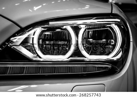BERLIN - SEPTEMBER 09, 2012: Showroom. Headlamp of a Grand tourer / executive coupe BMW 640i Gran Coupe (F06). Close-up. Black and white. Produced since 2012.