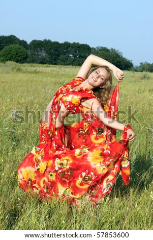 blonde in a bright dress dancing in a field
