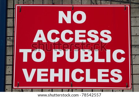 Red backed sign with \'NO ACCESS TO PUBLIC VEHICLES\' in white letters and a white border.