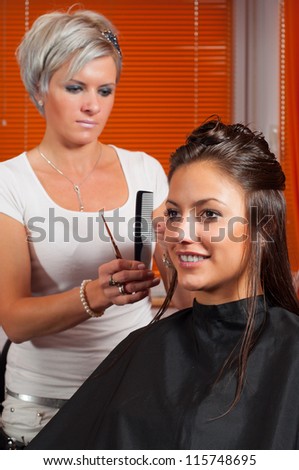 Hairdresser making hair of beautiful teenage girl.