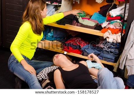 Teenage girls choosing clothes from the wardrobe.
