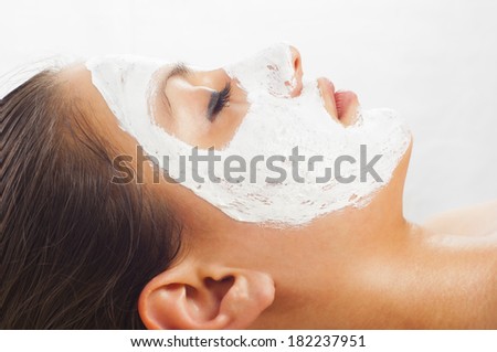 Beautiful young woman with natural facial mask on her face.