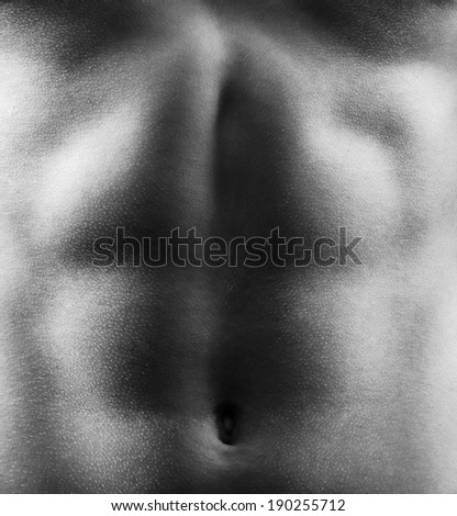 Muscular abdomen of the young man in black and white.