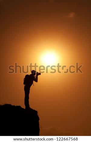 photographer\'s silhouette on a top of the hill