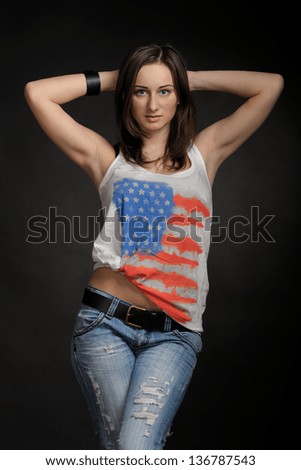 Woman in jeans and t-shirt on black background