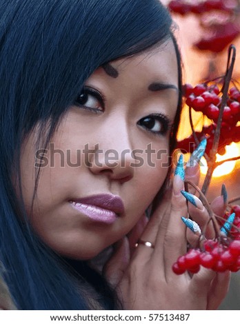 Beautiful asian girl with berry in hand