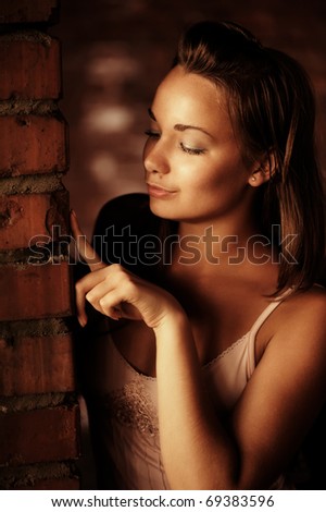 Portrait of beautiful woman near brick wall