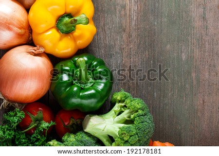 Vegetables on wood background with space for text. Farmers food. Bell pepper, onion, garlic, carrots and other vegetables.