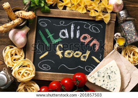 Italian food on vintage wood background, with chalkboard, with text