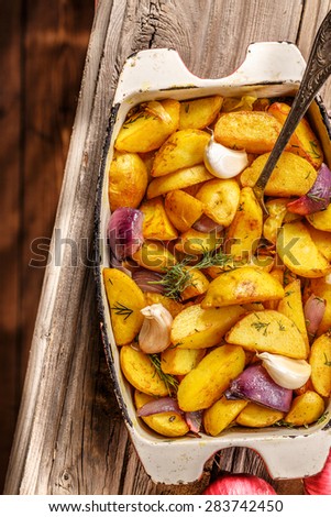 Rustic Fried Potato with vegetables on wooden background. Top view.