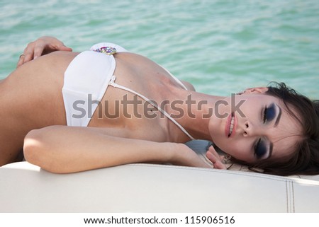 The beautiful girl lies on a boat and has a rest
