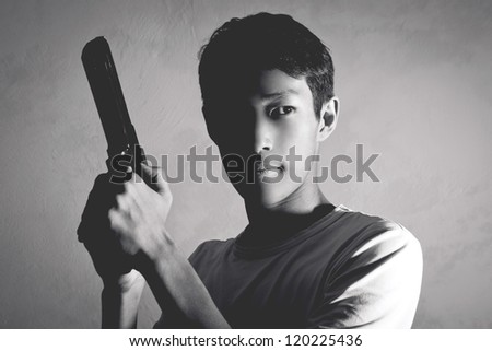 Portrait of Asian guy with a gun