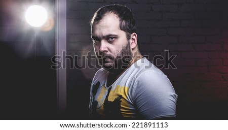 portrait of an angry guy near brick wall