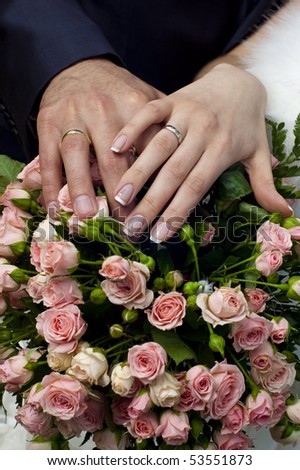 Wedding bouquet from tender roses, hands and rings
