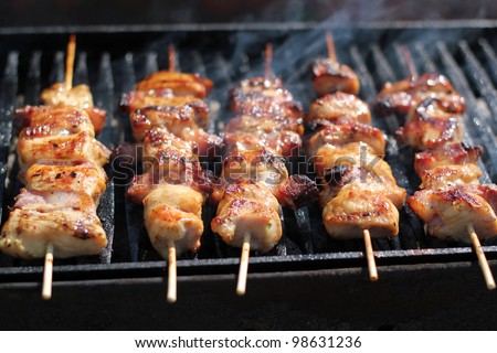 Chicken meat pieces being fried. Shallow DOF. Grilled chicken meat on the grill.\
Barbecue party. Delicious meat on bbq grill. Summer barbecue with chicken breasts.