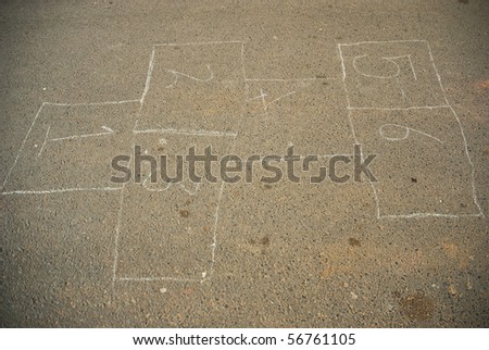 Hop scotch game drawn out on a road surface with white crayon